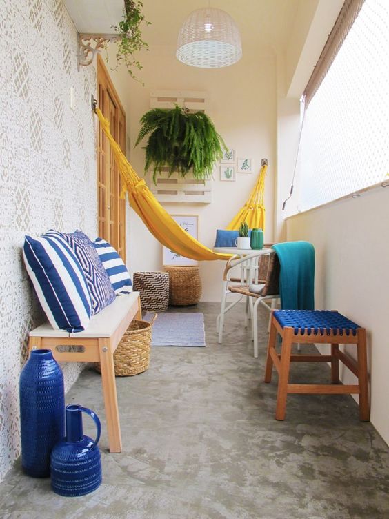 Colorful balcony with a yellow hammock, bold textiles, and greenery