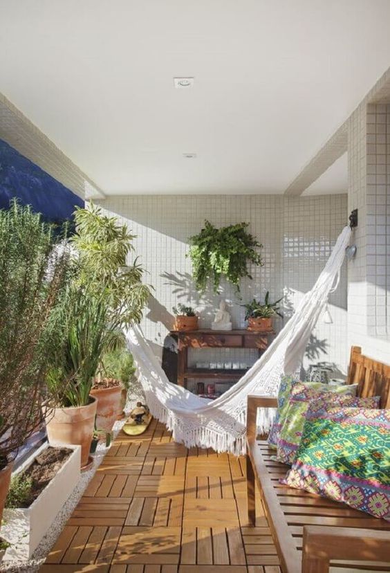 Bohemian balcony with macramé hammock and colorful pillows