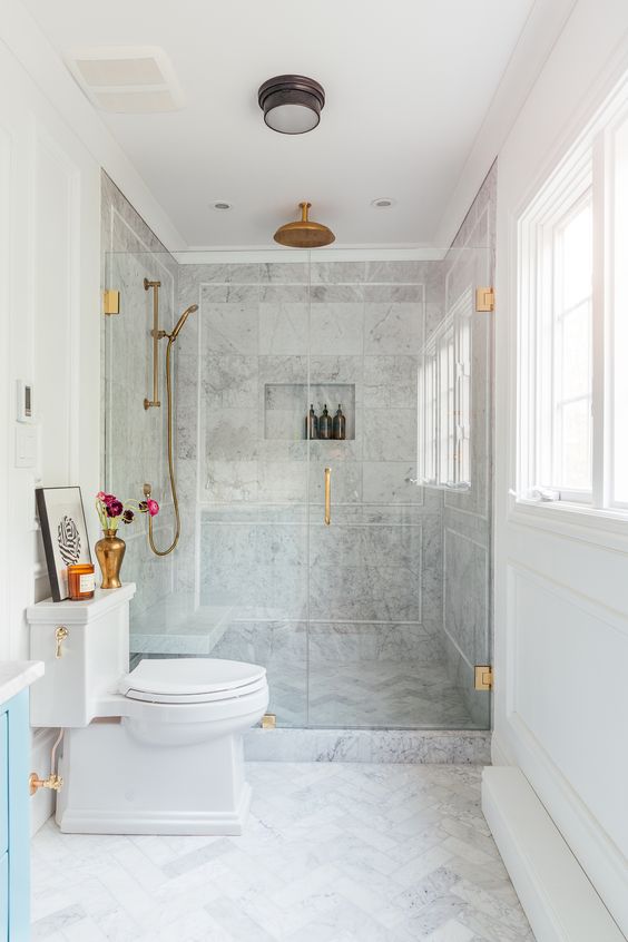 Neutral Marble Bathroom with Gold Fixtures and Blue Vanity
