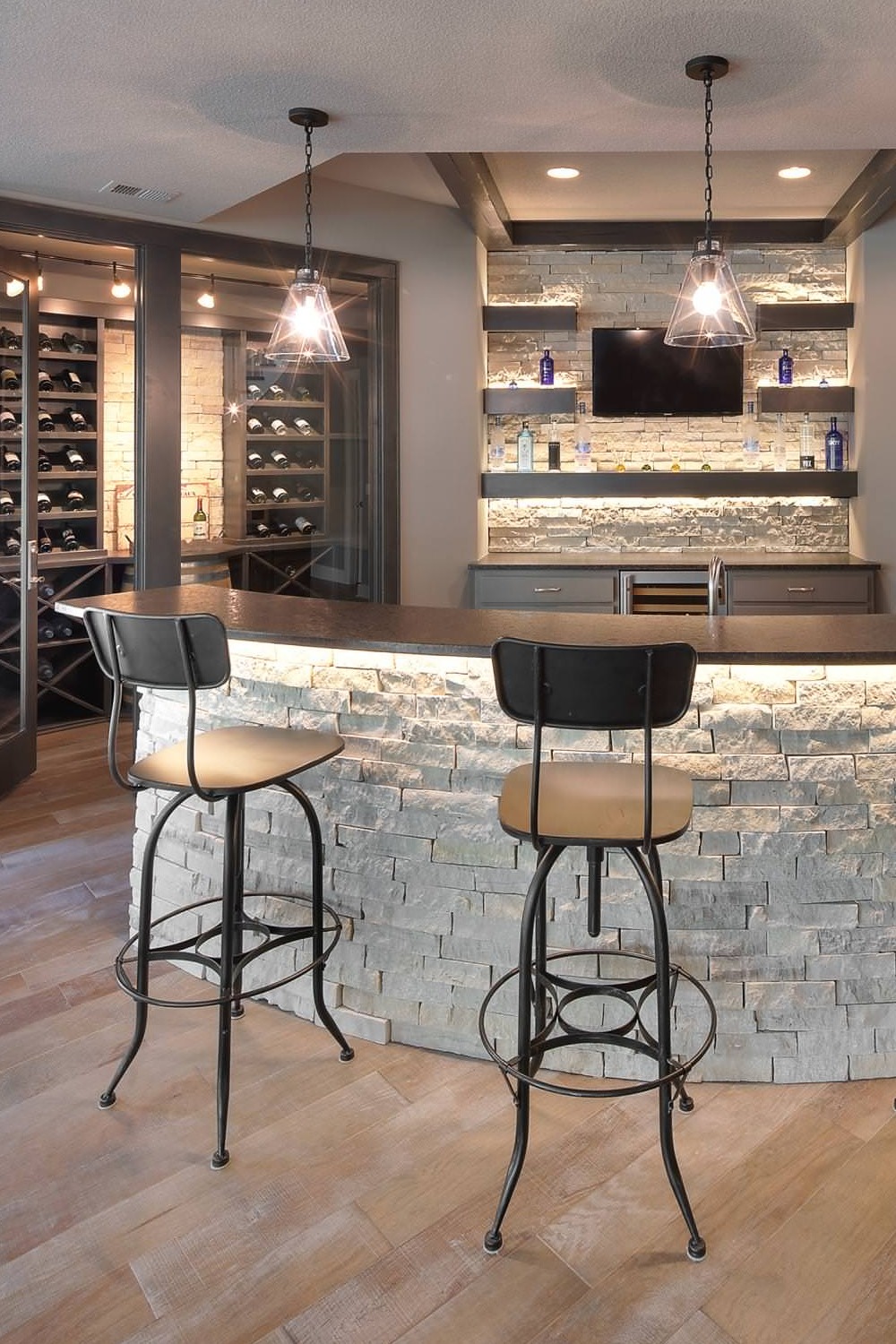 Modern Basement Bar with Dark Finishes and Bright Lighting