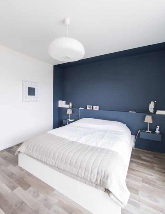 Minimalist Bedroom with Navy Accent Wall and Sculptural Lighting
