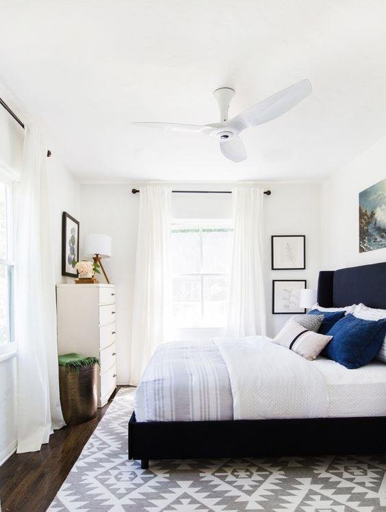 Textured Neutral Curtains in a Bedroom with Layered Rugs